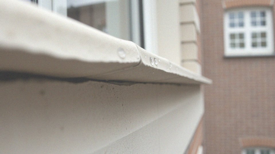 Jak parapet zewnętrzny zapobiega infiltracji wody pod obramowanie okna?